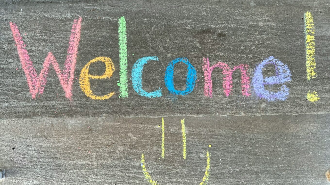 a welcome sign with a smiley face drawn on it